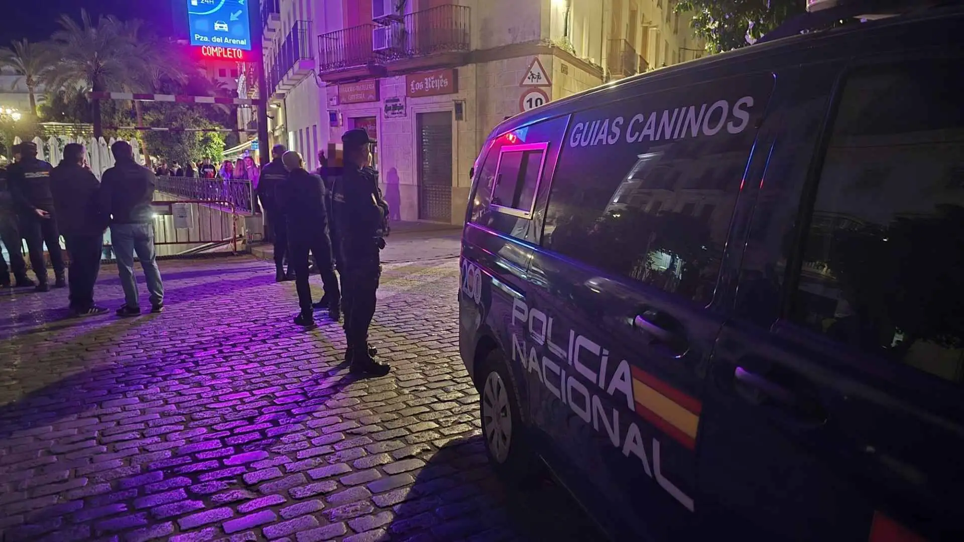 Furgón de la Unidad de Guías Caninos de la Policía Nacional estacionado de noche en la Plaza del Arenal junto a agentes vigilando el perímetro.