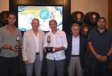 Personas en evento deportivo con trofeos en Xerez DFC y Atlético Sanluqueño.